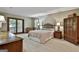 Serene main bedroom featuring a four-poster bed, soft carpeting, and private balcony access at 101 Longer Dr, Peachtree City, GA 30269