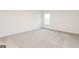 Spacious bedroom with neutral carpet, white walls, and a bright window at 235 Oliver Dr, Locust Grove, GA 30248
