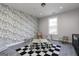 Bonus room features unique wallpaper, neutral colored table and seating, and black and white checkered rug at 235 Oliver Dr, Locust Grove, GA 30248