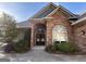 Elegant brick home showcasing an arched entrance with glass-paned doors and a well-manicured landscape at 6504 Cedar Mountain Rd, Douglasville, GA 30134