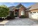 Charming brick home featuring an arched entrance, manicured landscaping, and a concrete driveway at 6504 Cedar Mountain Rd, Douglasville, GA 30134