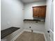 Functional laundry room with custom cabinets, folding table and tile flooring at 6504 Cedar Mountain Rd, Douglasville, GA 30134