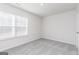 Bright bedroom featuring a large window that provides natural light, complemented by neutral walls and plush carpet at 455 Prescott Way, Villa Rica, GA 30180