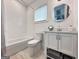 Bright bathroom featuring subway tile, a tub with shower, window, and vanity with round mirror at 300 Mado Ln # 329, Chattahoochee Hills, GA 30268