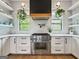 White kitchen featuring open shelving, stainless steel appliances, and subway tile backsplash at 300 Mado Ln # 329, Chattahoochee Hills, GA 30268