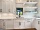 Bright kitchen with white cabinets, quartz countertops, stainless steel sink, and hardwood floors at 300 Mado Ln # 329, Chattahoochee Hills, GA 30268