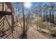 Backyard view with trees and foliage, stairs on left side of frame with sun shining at 2807 Knollview Dr, Decatur, GA 30034