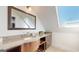 Bathroom features wood cabinets, granite counters, sink and a framed mirror with a skylight above at 2897 Macaw Nw St, Atlanta, GA 30318