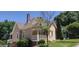 Exterior view of a tan home with a brick chimney, manicured shrubs and a well-kept lawn at 2897 Macaw Nw St, Atlanta, GA 30318