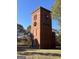 A brick water tower stands tall, adorned with a festive wreath on a sunny day at 2897 Macaw Nw St, Atlanta, GA 30318