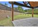 Inviting outdoor space with a covered patio, stone pavers, and a well-maintained lawn with a retaining wall at 1240 Hayes Sq, Peachtree City, GA 30269