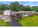 Charming single-story home with a welcoming front porch, a detached garage, and lush greenery at 80 David Rd, Hampton, GA 30228