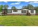 Attractive single-story home with dark trim, green grass, and a covered front porch at 80 David Rd, Hampton, GA 30228