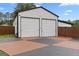 Detached garage with two roll-up doors and a stained driveway at 80 David Rd, Hampton, GA 30228