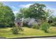 Charming home featuring a lush green yard, mature trees, and a well-maintained exterior at 125 Burnside St, Jonesboro, GA 30236