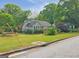 A cozy home surrounded by mature trees and a lush yard, enhancing its curb appeal at 125 Burnside St, Jonesboro, GA 30236