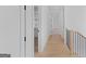 Hallway with light hardwood floors and white walls, showing open doorways and modern finishes at 915 Laurel Brooke Ave, Peachtree City, GA 30269