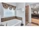 Bathroom featuring a soaking tub next to a window, and a glass door leading into the stand up shower at 3259 Baylor Cir, Mcdonough, GA 30253