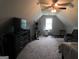 Finished bedroom with sloped ceilings, entertainment center and gray reclining loveseat at 416 Line Creek Cir, Sharpsburg, GA 30277