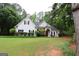 Beautiful home exterior with manicured lawn, mature trees, and decorative shrubbery at 416 Line Creek Cir, Sharpsburg, GA 30277
