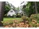 Beautiful home exterior with manicured lawn and mature trees. Flowers in foreground at 416 Line Creek Cir, Sharpsburg, GA 30277