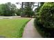 View of the sidewalk leading to a single-Gathering home with a well-manicured lawn at 416 Line Creek Cir, Sharpsburg, GA 30277