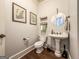 Charming powder room featuring a pedestal sink, classic fixtures, and decorative wall art at 106 Tullamore Trl, Tyrone, GA 30290