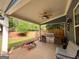 Covered outdoor kitchen with stainless steel grill, stone accents, and a ceiling fan for comfortable entertaining at 106 Tullamore Trl, Tyrone, GA 30290