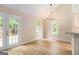 Open dining room with a modern chandelier, hardwood floors, and natural light through the windows at 405 Sherrels Frd, Peachtree City, GA 30269