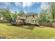 Expansive backyard with a deck, patio, mature trees, and wooden fencing, providing privacy at 5045 Rock Springs Rd, Lithonia, GA 30038