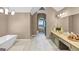 Large bathroom with soaking tub, dual vanity, arched window, and a tiled floor at 5045 Rock Springs Rd, Lithonia, GA 30038
