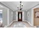 Inviting foyer with a beautiful wooden front door, chandelier, and decorative accents throughout at 5045 Rock Springs Rd, Lithonia, GA 30038