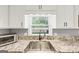 Modern kitchen featuring granite countertops and stainless-steel sink at 5045 Rock Springs Rd, Lithonia, GA 30038