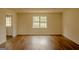 A bright, empty living room with laminate flooring and a large window with natural light at 7017 Sun Valley Way, Riverdale, GA 30274