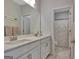 Bathroom featuring double sinks, white cabinets, large mirror, and a doorway to the toilet and shower area at 221 Caledonia Ct, Peachtree City, GA 30269