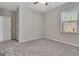 Empty bedroom with gray walls, carpeted floor, window, and a door to the closet at 221 Caledonia Ct, Peachtree City, GA 30269