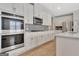 This kitchen has stainless steel appliances, white cabinets, and light-toned wood floors at 221 Caledonia Ct, Peachtree City, GA 30269