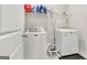 Convenient laundry room equipped with a washer, dryer, and storage shelves at 221 Caledonia Ct, Peachtree City, GA 30269