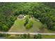 Aerial view of property featuring two homes, surrounded by large trees, and an open field at 333 Old Carrollton Rd, Roopville, GA 30170