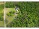 This aerial view showcases a private residence with a long driveway nestled amongst mature trees at 333 Old Carrollton Rd, Roopville, GA 30170