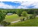 Aerial view of property surrounded by large trees, and open green space at 333 Old Carrollton Rd, Roopville, GA 30170