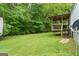 Backyard showing a wooden porch attached to the home, surrounded by lush trees and lawn at 333 Old Carrollton Rd, Roopville, GA 30170