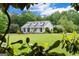 Exterior view showcasing a home with beautiful landscaping and a sprawling green lawn framed by mature trees and foliage at 333 Old Carrollton Rd, Roopville, GA 30170