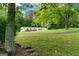 Exterior shot of a white single-Gathering home surrounded by trees and a large grassy lawn at 333 Old Carrollton Rd, Roopville, GA 30170