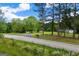 Road leading to house with manicured lawn, trees, and blue sky overhead at 333 Old Carrollton Rd, Roopville, GA 30170
