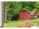 Red outbuilding on a well-maintained lawn with lush greenery at 333 Old Carrollton Rd, Roopville, GA 30170