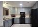 Well-lit kitchen with black appliances and gray cabinets at 5851 Giles Rd, Lithonia, GA 30058