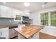Modern kitchen featuring stainless steel appliances, butcher block countertops, white cabinets, hardwood floors, and natural light at 2952 Diana Sw Dr, Atlanta, GA 30315