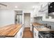 Modern kitchen featuring stainless steel appliances, butcher block countertops, white cabinets, and hardwood floors at 2952 Diana Sw Dr, Atlanta, GA 30315