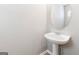 Stylish powder room with a pedestal sink, round mirror, and light paint enhances this home at 1360 Maple Valley Ct, Union City, GA 30291